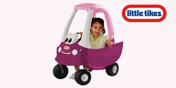 A girl sitting on a Little Tikes cozy coupe.